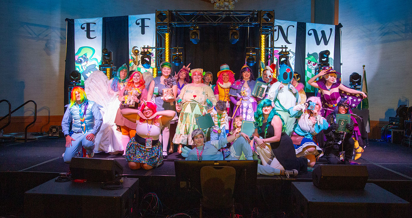 Cosplay contest participants pose on stage.